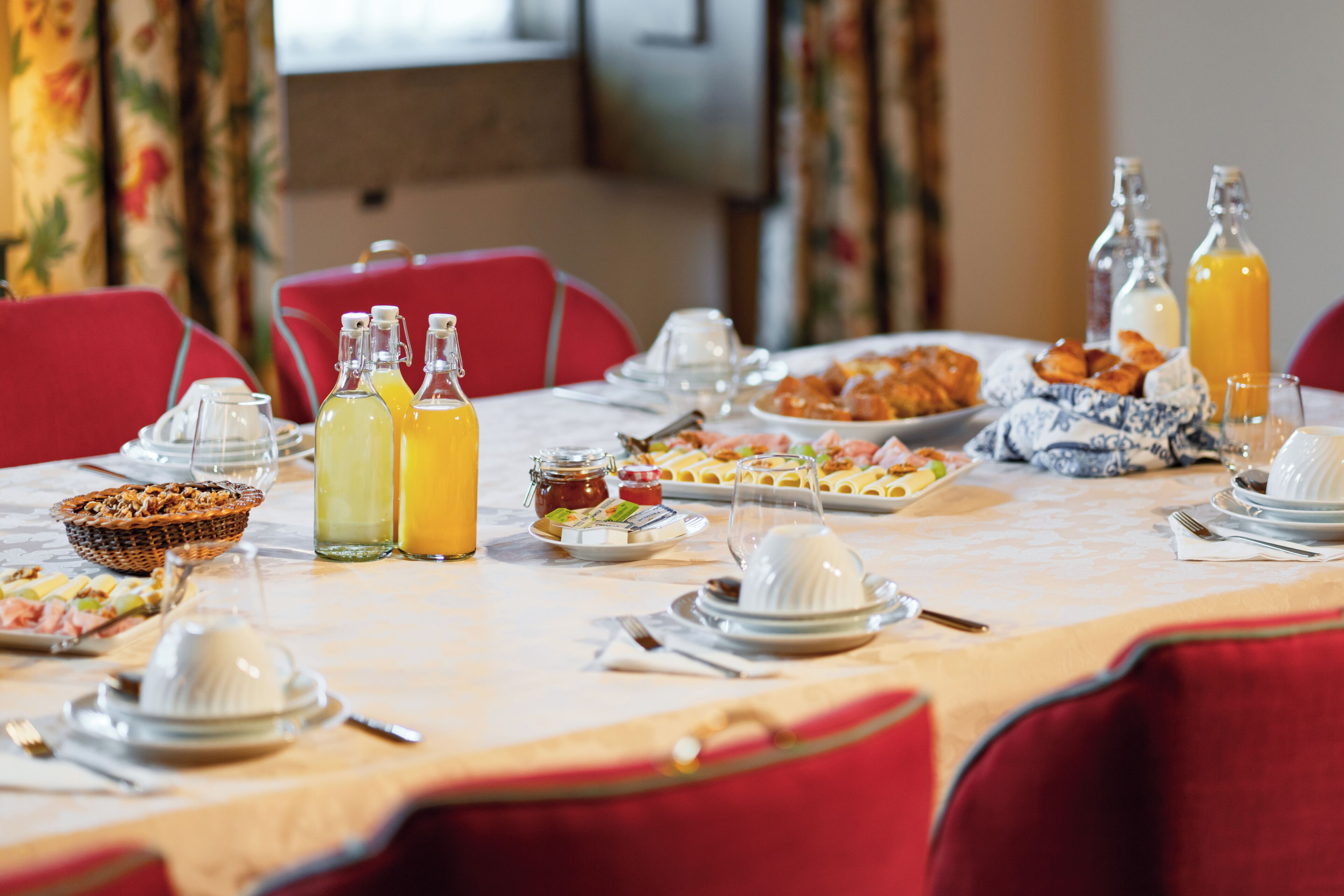 Un bufé de desayuno con diversos platos, bebidas y una mesa lista para comer.