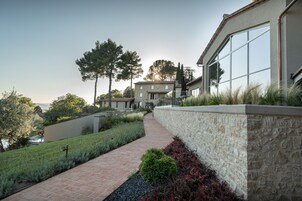 Una casa moderna con un camino de piedra que lleva a un gran ventanal.