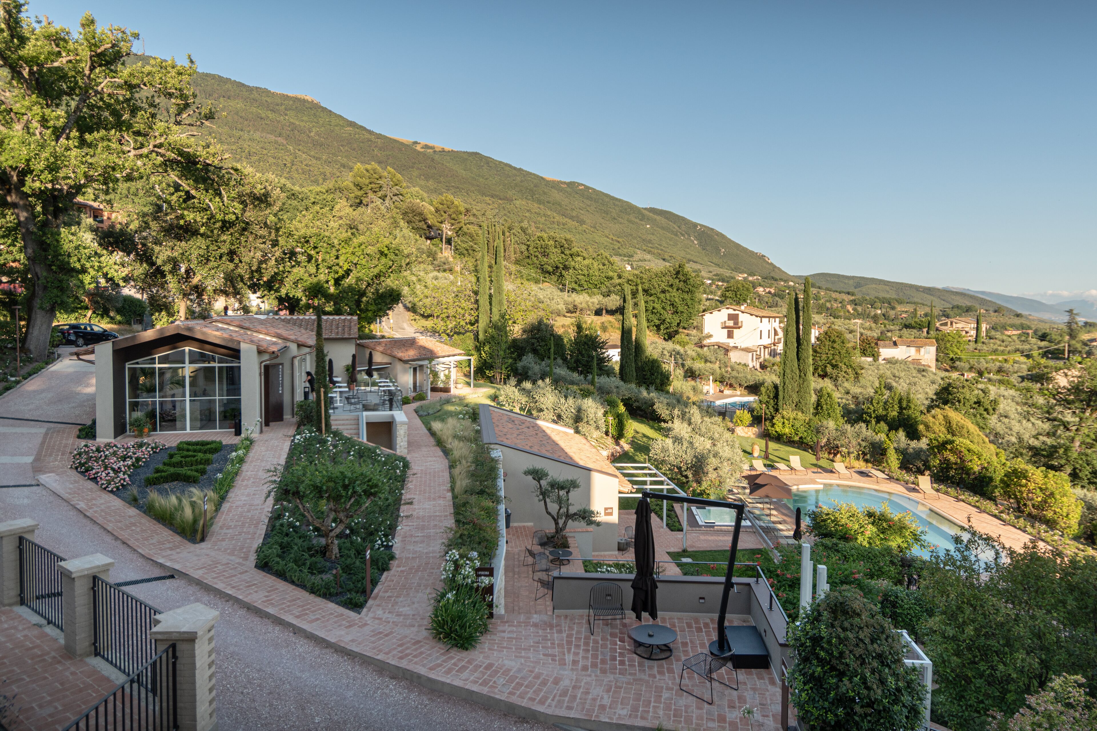 A residential property with a swimming pool, patio furniture, and a landscaped garden.