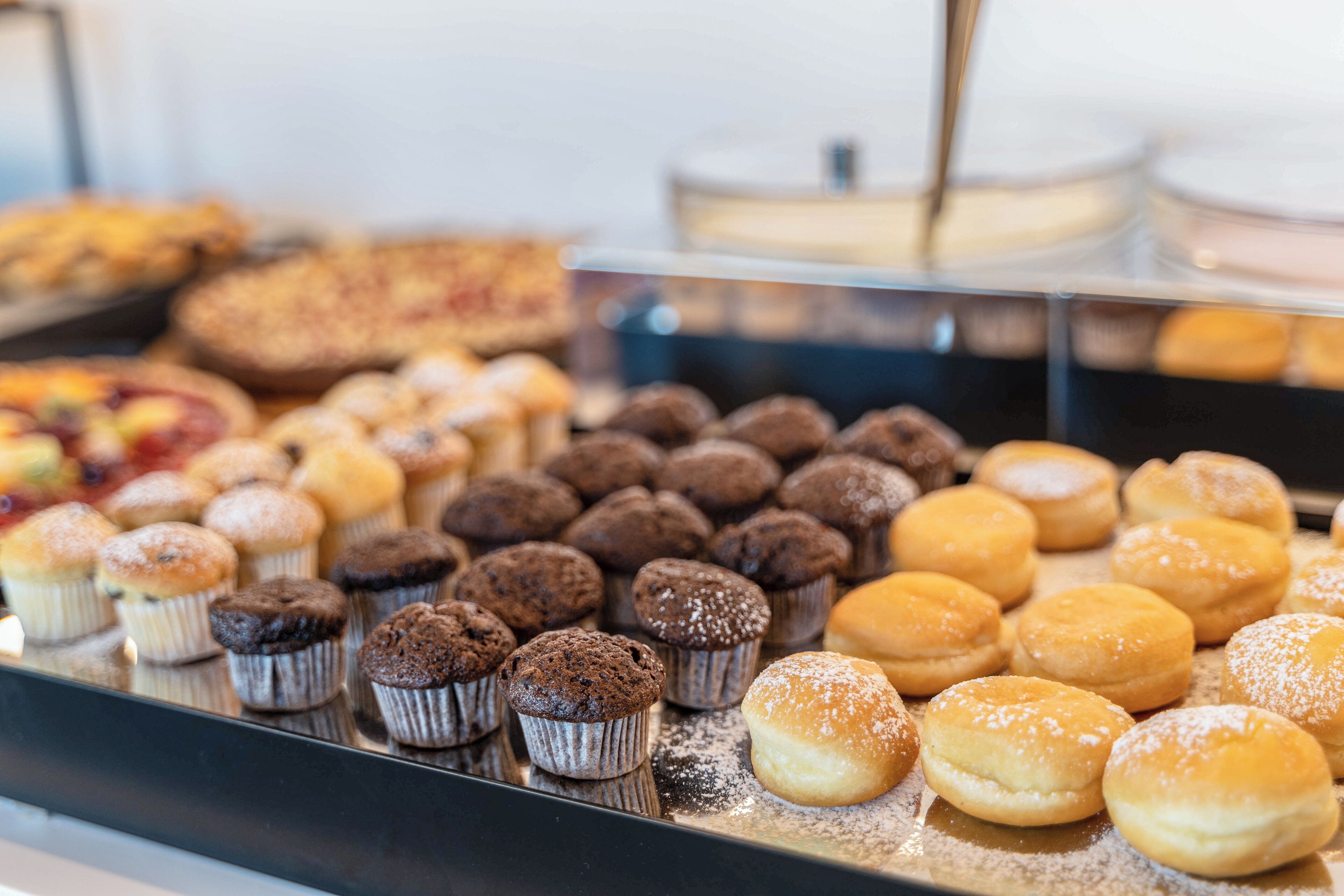 A display of various baked goods including muffins and pastries.