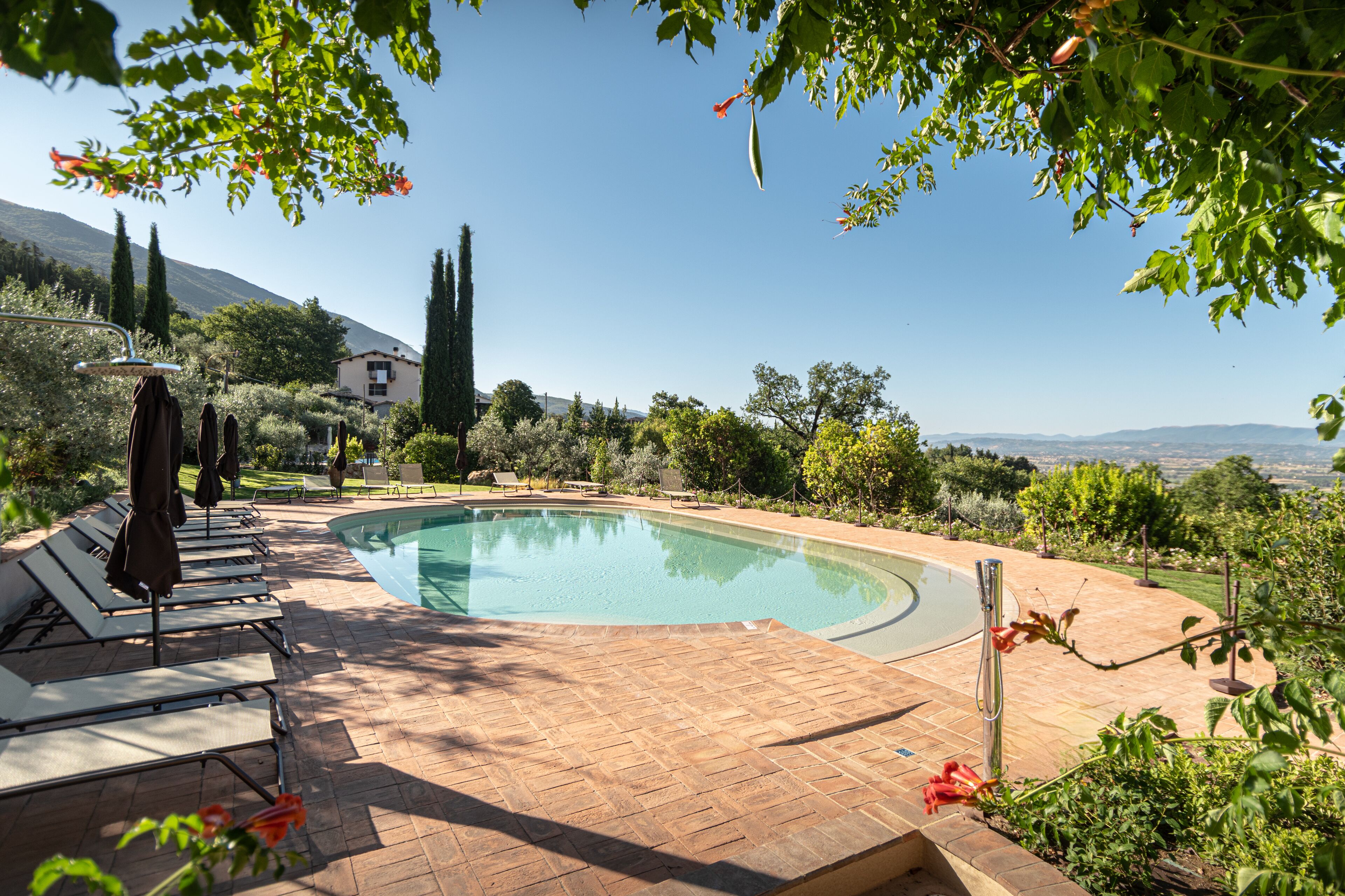 A swimming pool with lounge chairs and a view of the countryside.