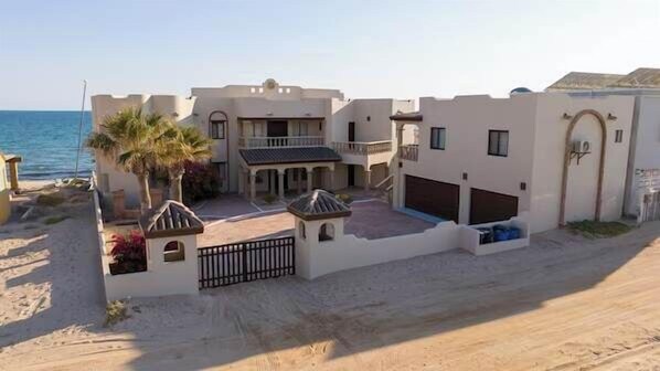 Una propiedad costera con un amplio patio, garaje y vista al mar.