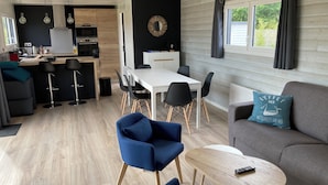 Un espace de vie moderne comprenant un coin repas, une cuisine et un coin salon.