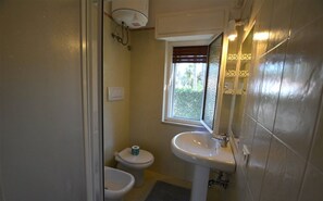 A compact bathroom with a toilet, bidet, and sink.