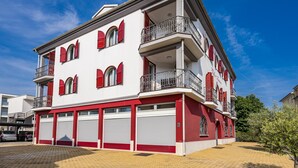 A multi-story building with red shutters, a balcony, and a garage. - Studio apartment for 2 in Villa Armin (Rovinj)