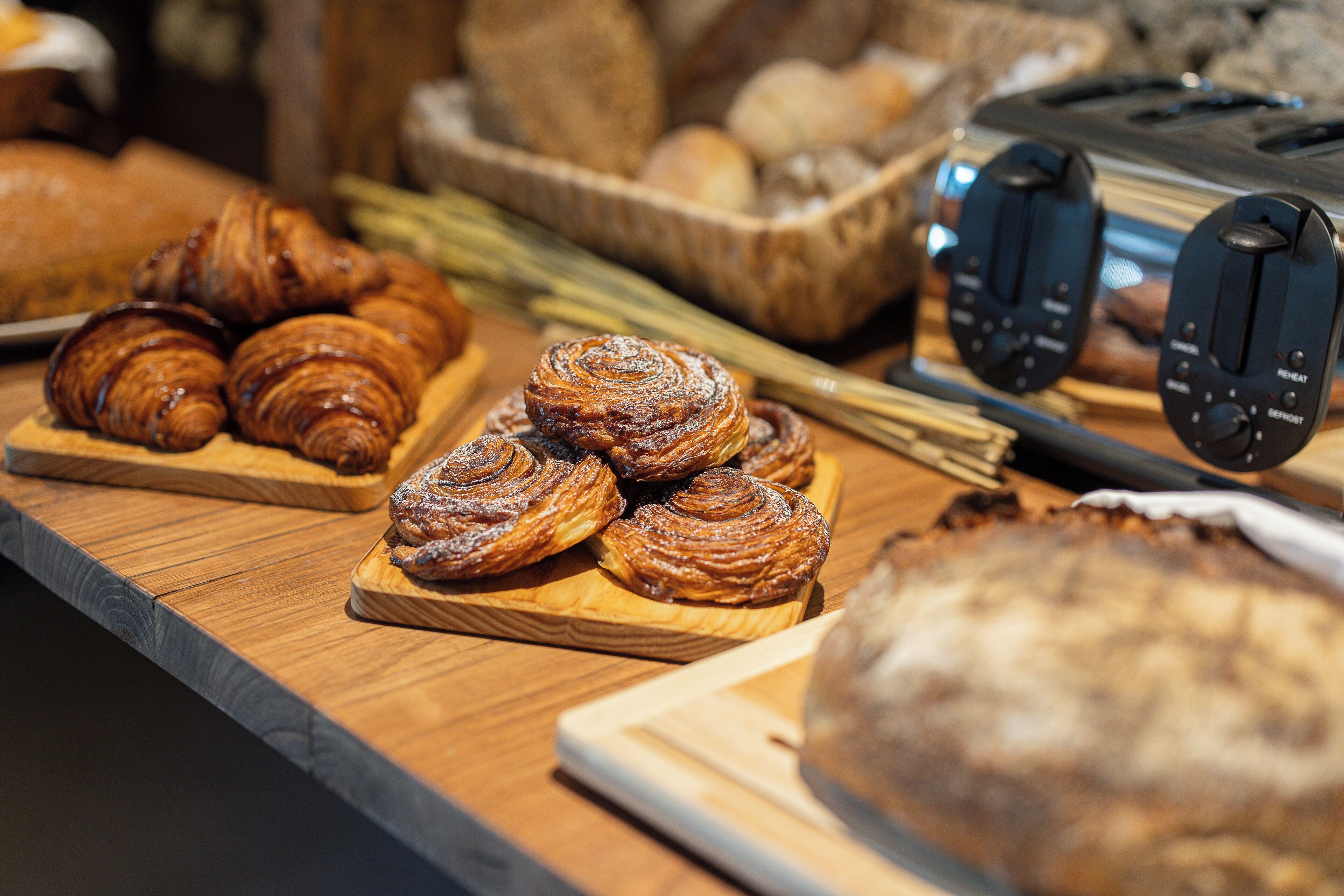 Balcão de pastelaria com croissants e pão.