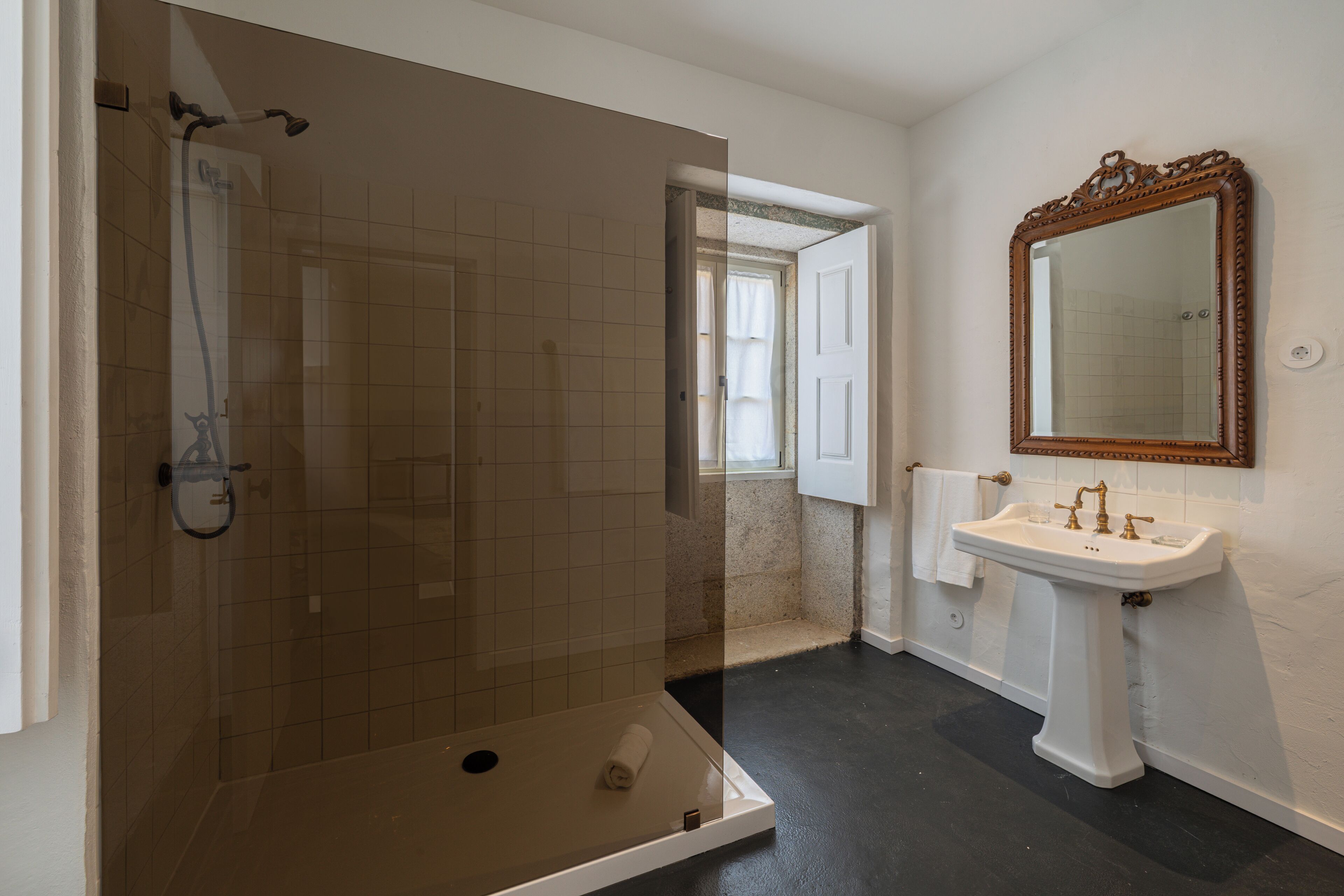 A bathroom with a shower, a sink, and a mirror.