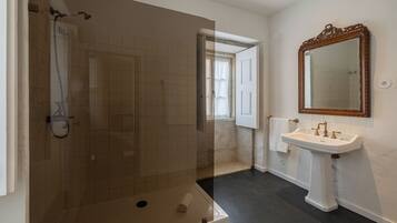 A bathroom with a shower, a sink, and a mirror.