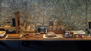Un bufé de desayuno con panes, pasteles y diferentes salsas.