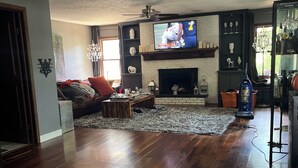 A living room with a fireplace, a television, and a sofa.