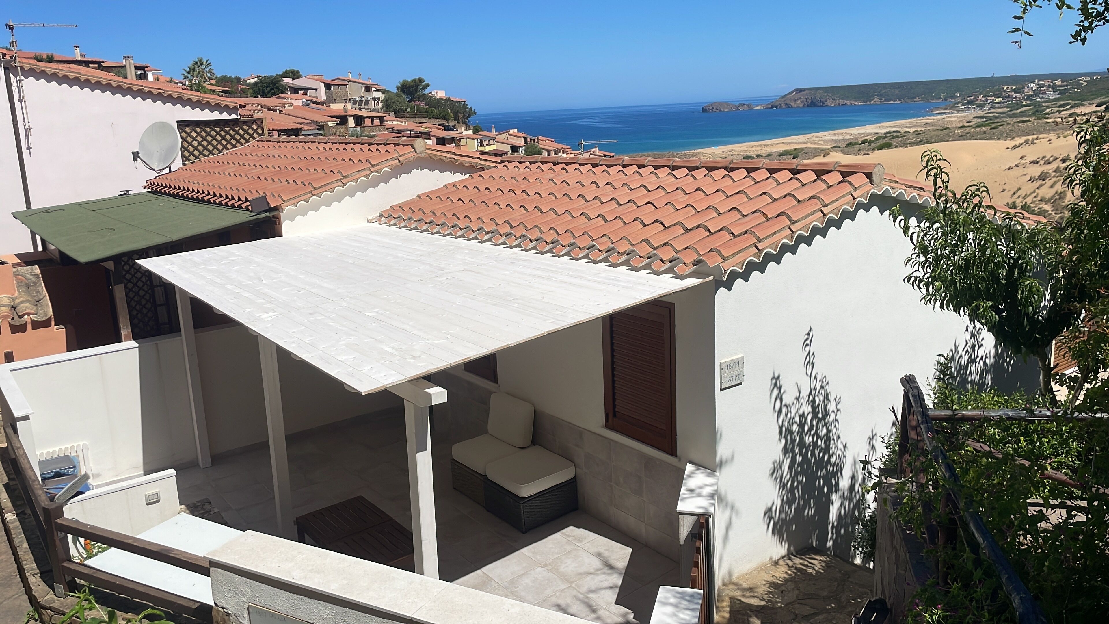 Un edificio residencial con techo de tejas, balcón y vista al mar.