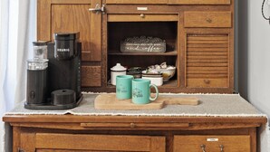 A wooden cabinet with a coffee bar sign, a French Bulldog figurine, and a coffee maker. - Private Hot - Private Yards - WIFI (Fredericksburg)