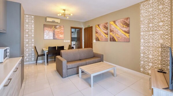 A modern living room with a sofa, coffee table, and artwork on the walls.