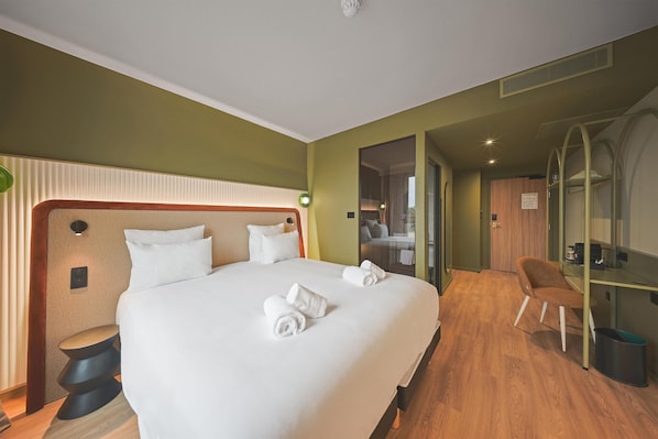 A hotel room with a large bed, a desk, and a chair. - Campanile PRIME - Smart Lyon Chaponost (Chaponost)