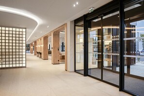 Un interior moderno con techo curvo, paneles de madera y puertas de cristal que dan a un espacio exterior.