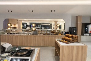 Una cocina moderna con una isla central, una cafetera y diversos alimentos a la vista.