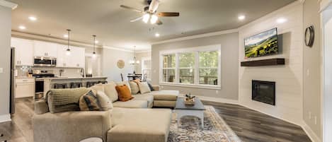 A modern living room with a sectional sofa, a coffee table, and a fireplace.