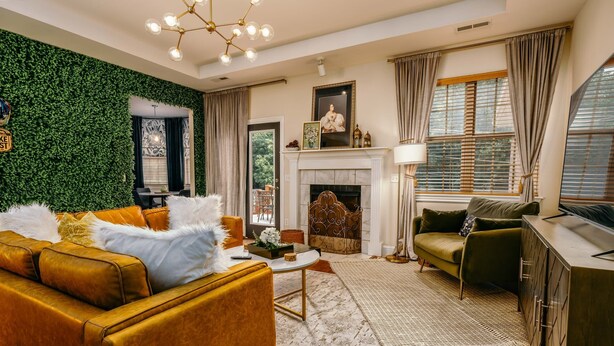 A living room with a green wall, a fireplace, and a sofa.