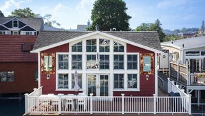 A waterfront house with a balcony, large windows, and a dock. - Stay at Smith Cove (Gloucester)