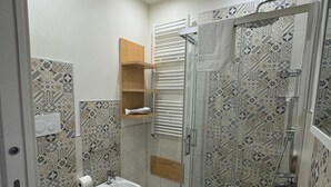 A modern bathroom with a glass-enclosed shower, a freestanding sink, and a bidet. - Rupella  (Roccella Jonica)