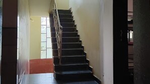 Un escalier menant à l’étage supérieur, avec une paire de chaussures posée sur le sol, en bas.