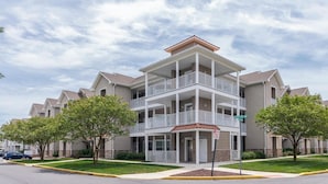 A multi-story residential building with balconies, a fire lane sign, and a street sign indicating "SLOPPER SHELL WAY". - Condo with Community Pool - 17432 Slipper Shell Way Unit 1 (Lewes)