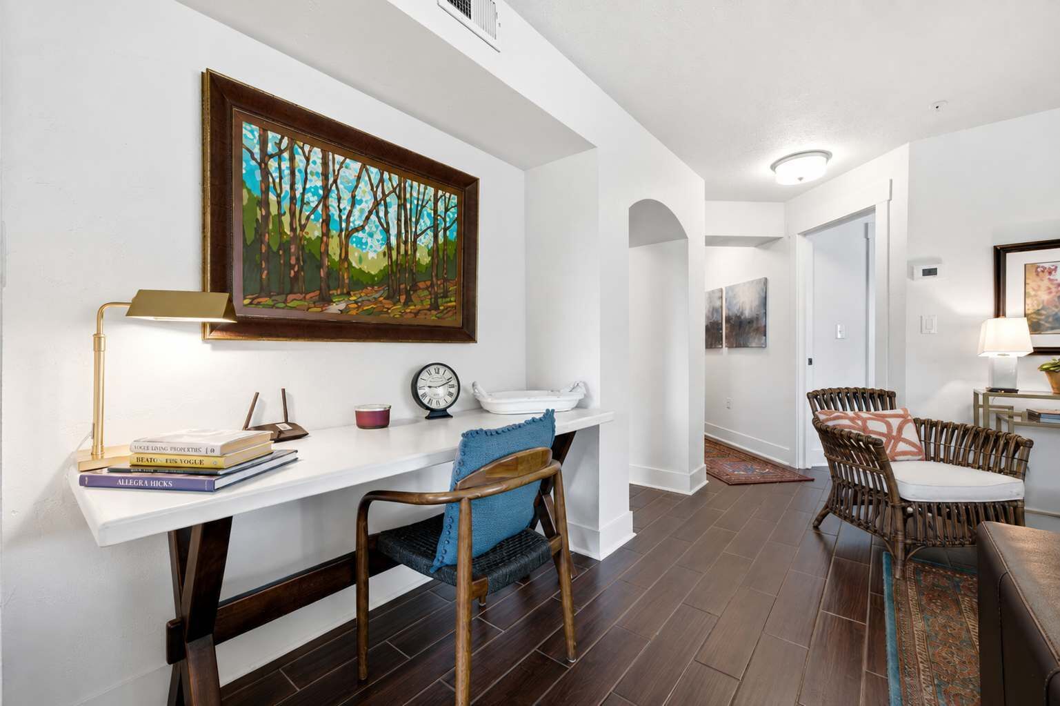 Une pièce bien éclairée, avec un bureau, une chaise et un coin repas équipé de chaises.