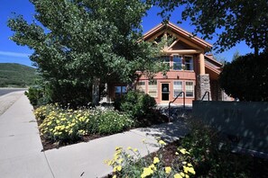 A two-story building with a stone facade, a red roof, and a front entrance with a door.