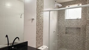 Une salle de bain moderne avec un plan de toilette noir, un lavabo blanc et des toilettes.