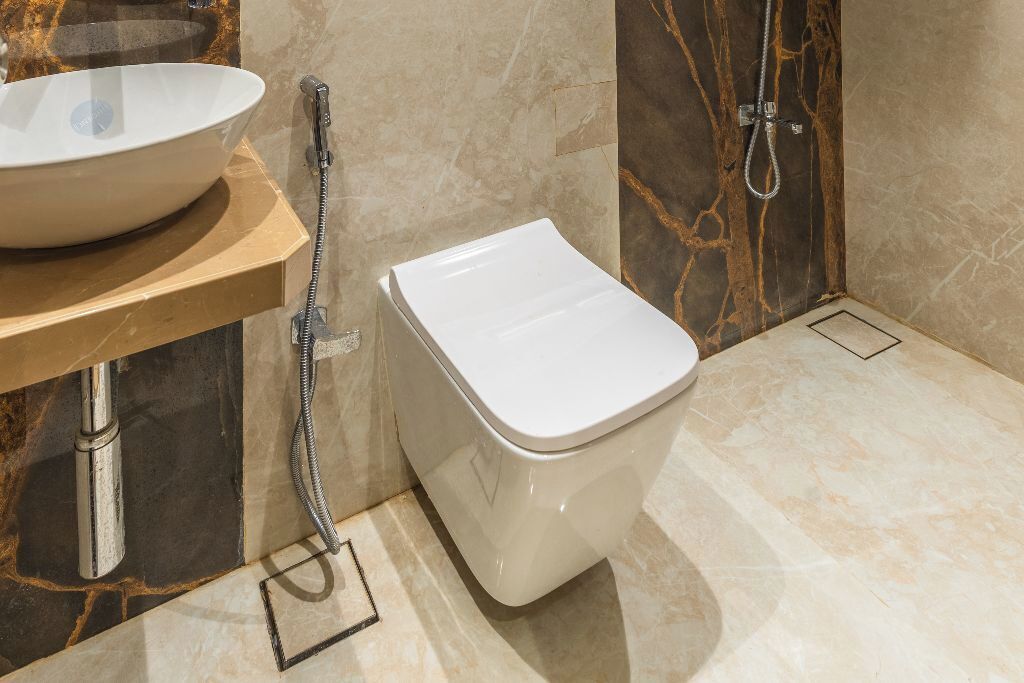 A bathroom with a white toilet, a sink with a bowl, and a shower.