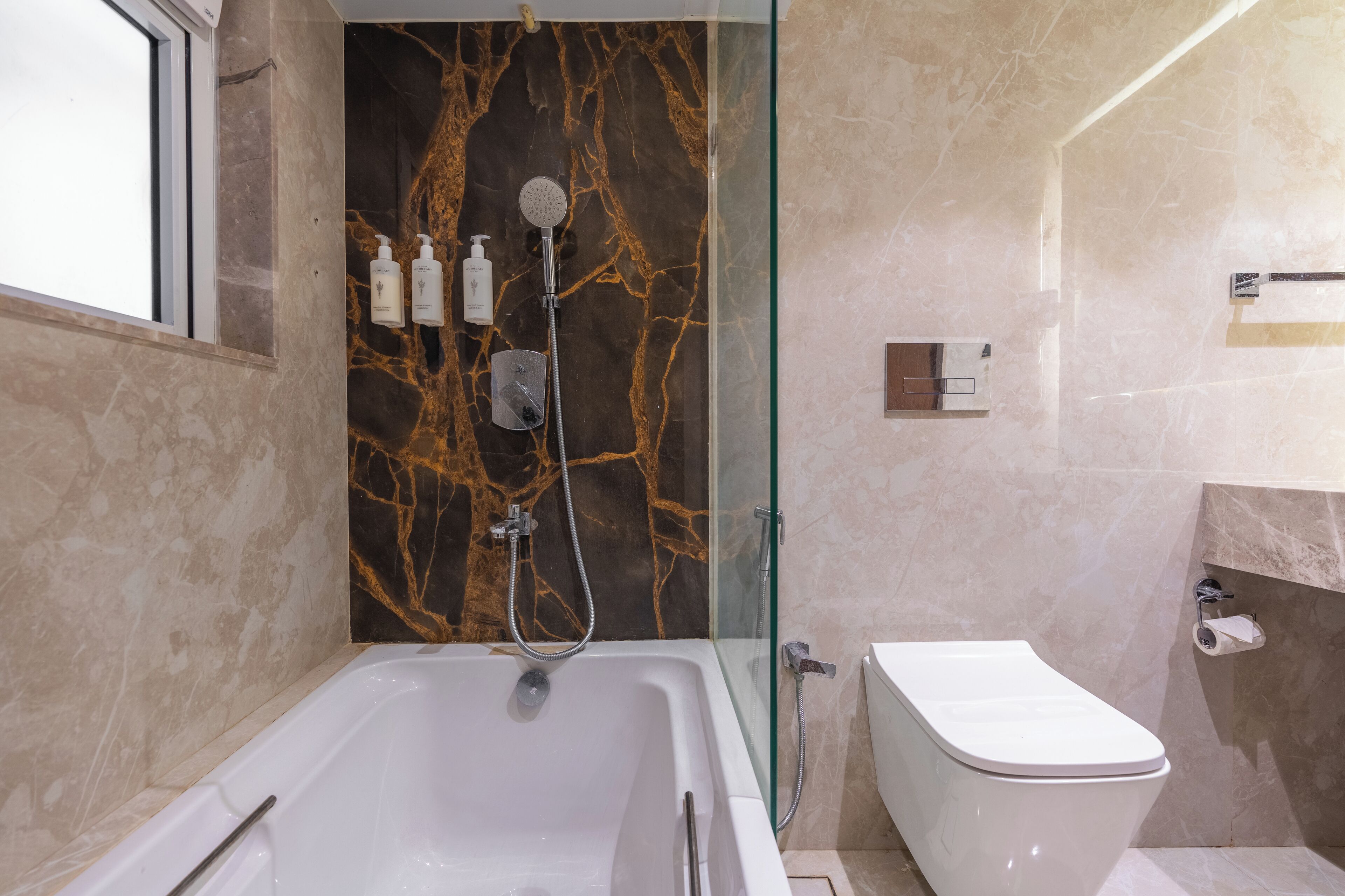 A modern bathroom with a glass-enclosed shower, a white bathtub, and a toilet.