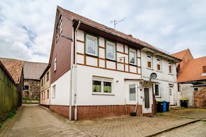Ein zweistöckiges Haus mit Ziegelaußenwand, weißem Zierdekor und einem Ziegeldach.