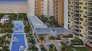 Un resort con piscina, varios balcones y vista al océano.