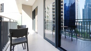 Un appartamento moderno con un balcone, ampie finestre e vista sulla città.