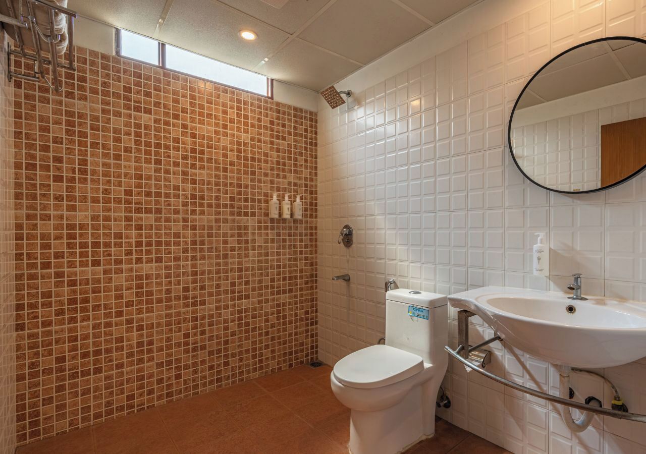 A bathroom with a shower, toilet, and sink.