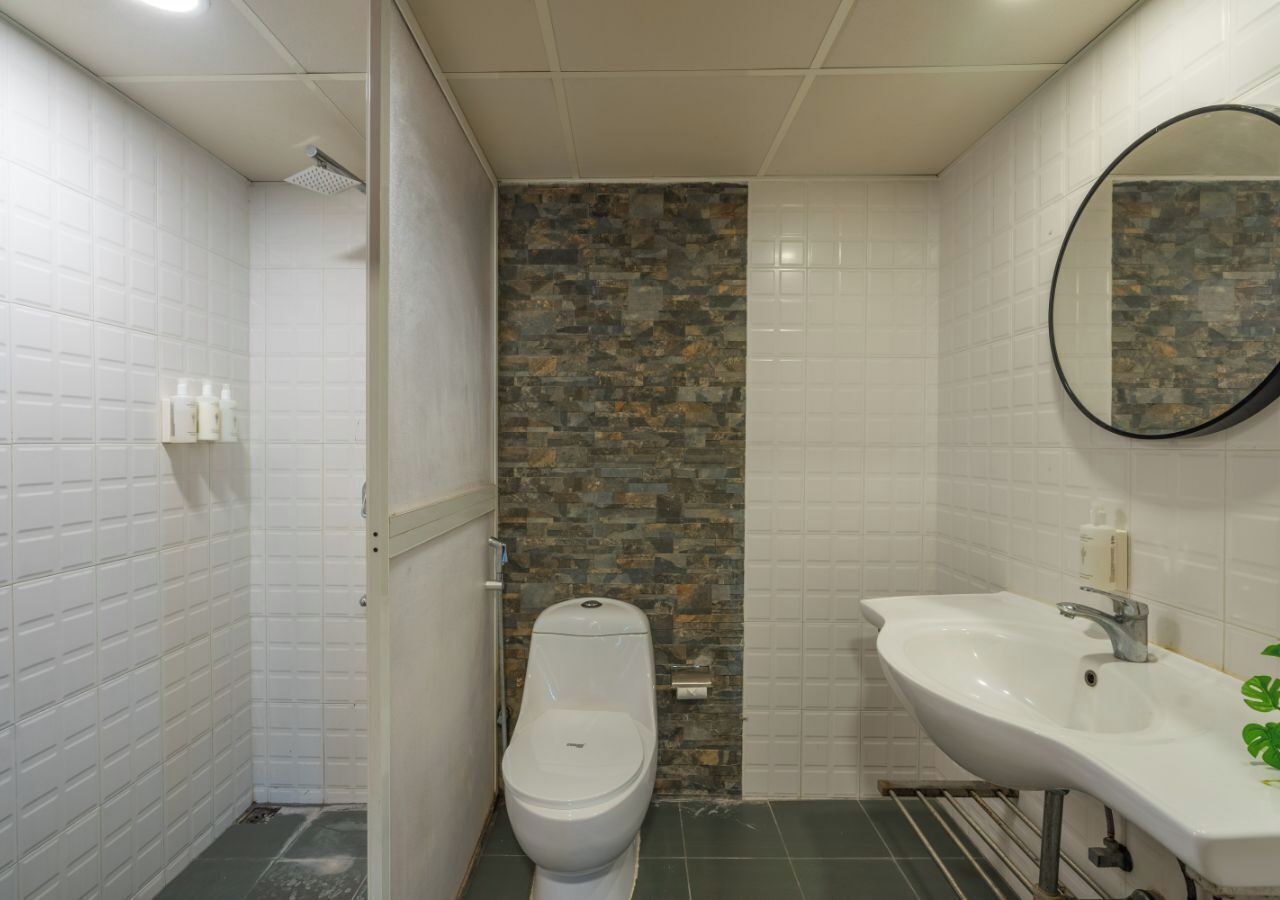 A bathroom with a toilet, a sink, and a shower area.