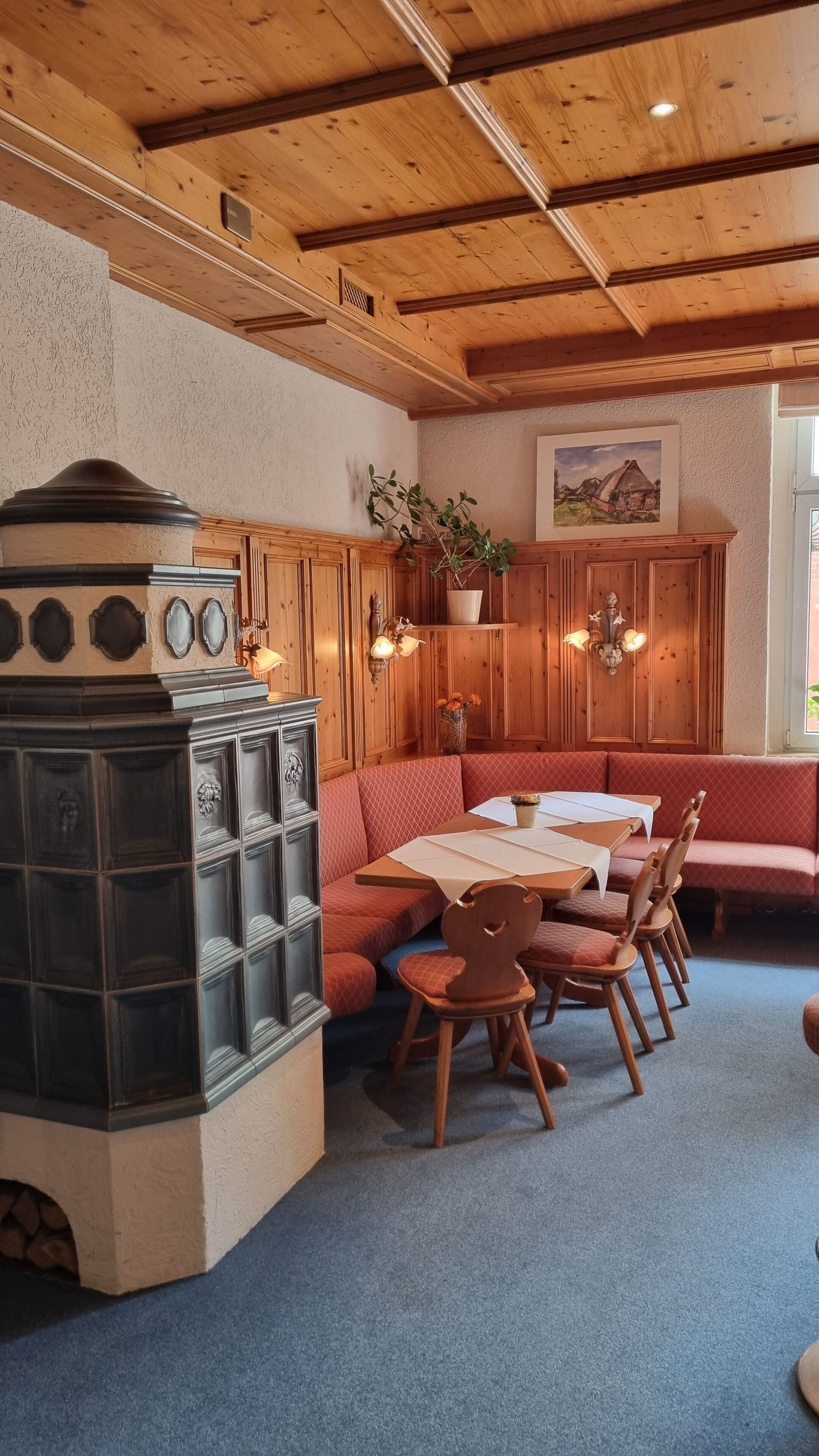 Un comedor acogedor con una mesa y sillas de madera, un banco empotrado y una chimenea.
