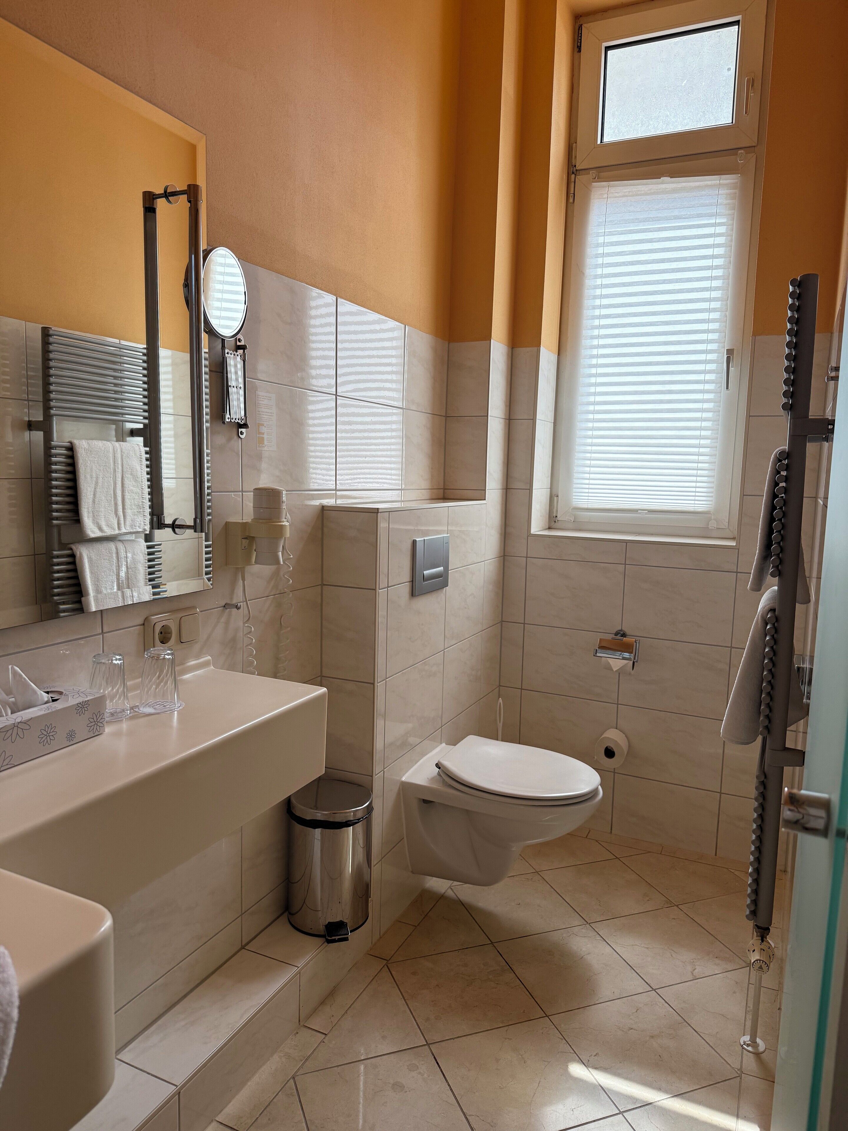 Ein Badezimmer mit Waschbecken, Toilette und Duschbereich.
