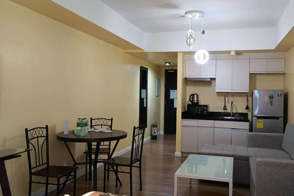 A compact living space with a dining area, kitchenette, and seating area.