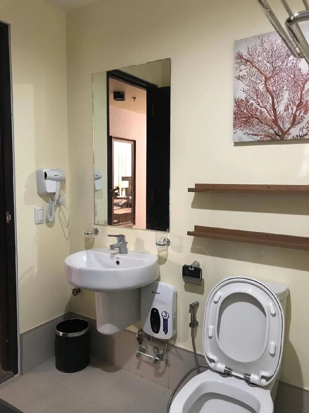 Une salle de bain avec un lavabo, des toilettes et un miroir.