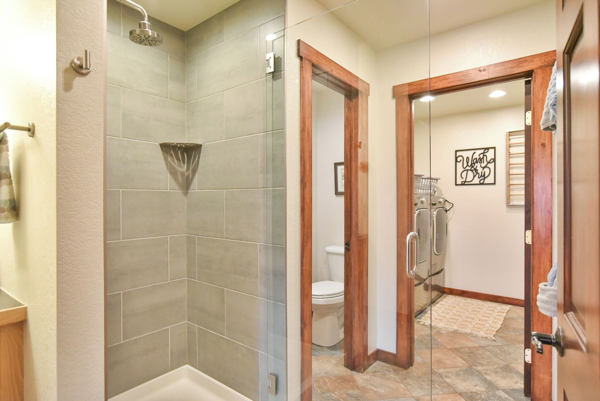 Une salle de bain avec une douche, des toilettes et un miroir.