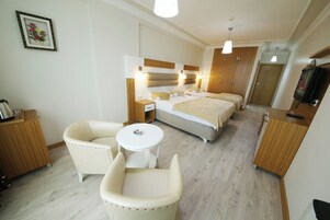 Minibar, escritorio, cortinas blackout y tabla de planchar con plancha