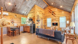 Ein gemütliches Blockhaus mit Essbereich, Küche und Wohnzimmer.