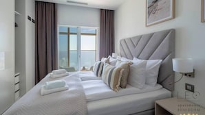 A hotel room with a large bed, a bedside table, a lamp, and a window with curtains. - Intempo Spa (Benidorm)