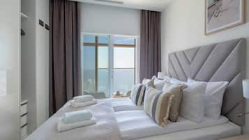 Une chambre d’hôtel avec un grand lit, une table de chevet, une lampe et une fenêtre avec des rideaux.
