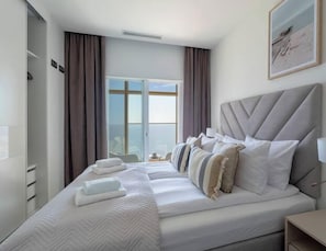 A hotel room with a large bed, a bedside table, a lamp, and a window with curtains. - Intempo Spa (Benidorm)