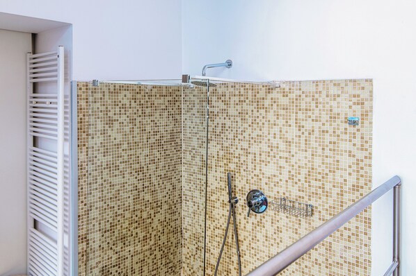 A shower enclosure with a tiled mosaic wall, a handheld showerhead, and a metal handrail. - JOIVY Al Duomo guest house (Como)