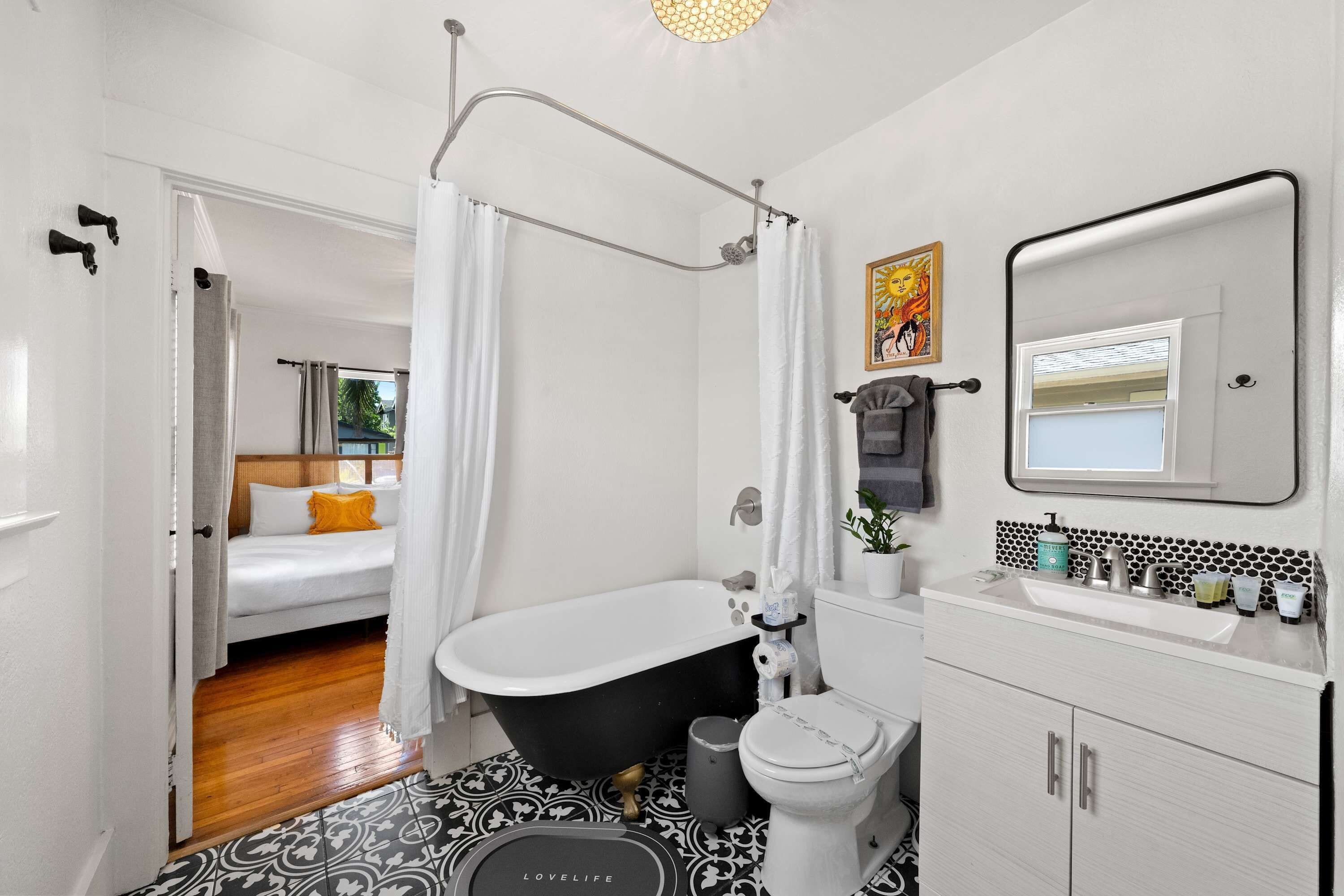 A bathroom with a bathtub, toilet, and sink. There is a shower curtain and a towel rack.