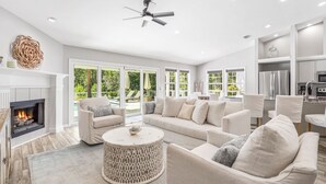 A spacious living room with a fireplace, comfortable seating, and a view of the outdoors. - Dog-Friendly House with Private Pool (Santa Rosa Beach)