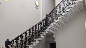 A grand staircase with ornate black railings and stone steps.